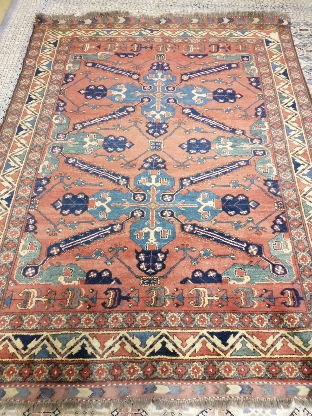 An Afghan Kazak red ground rug, centred by two quatrefoil blue ground medallions, multi-bordered, 236 x 179cm